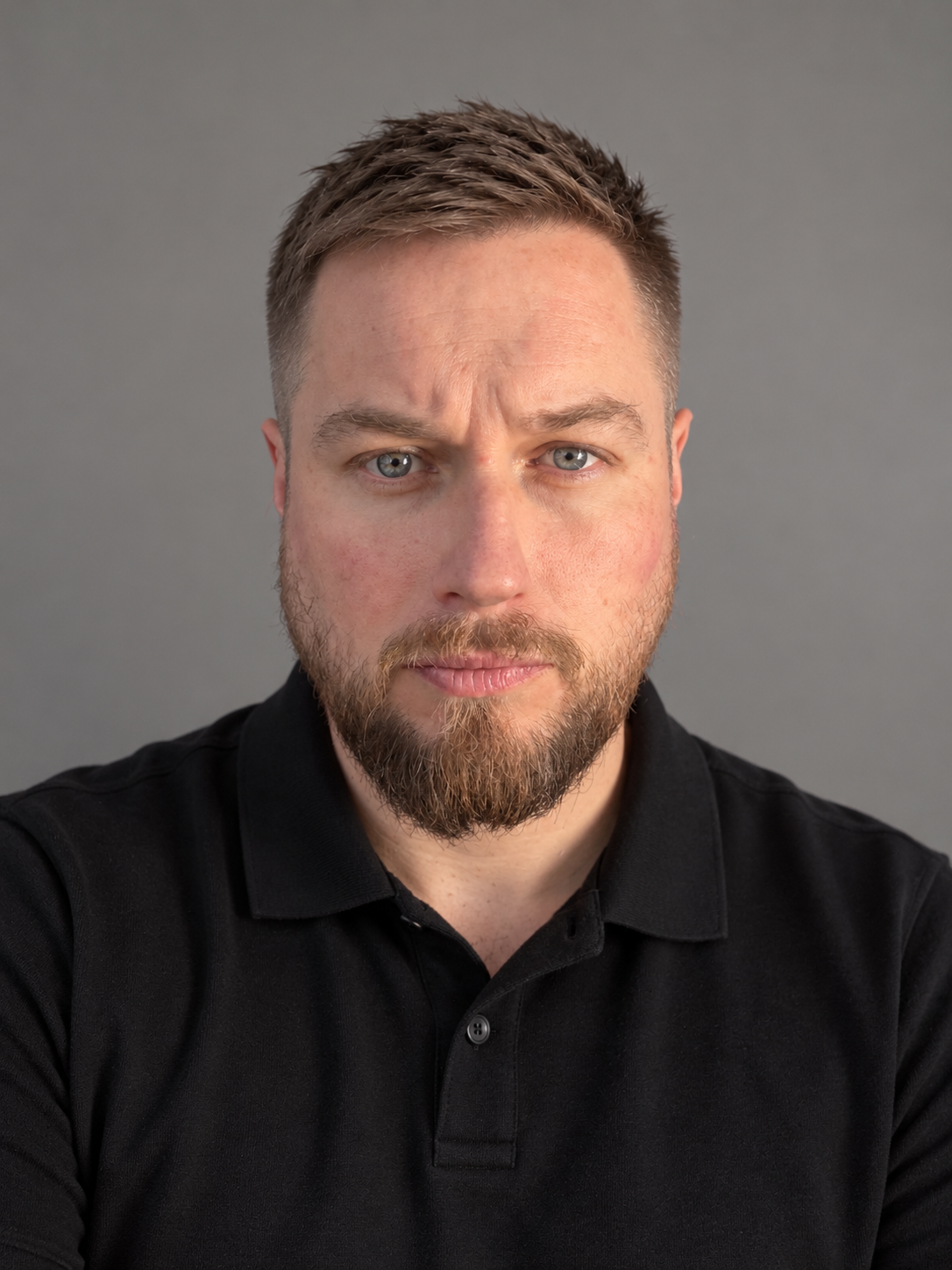 Tom Wardhaugh, founder of Integrity QA, wearing a plain black polo shirt